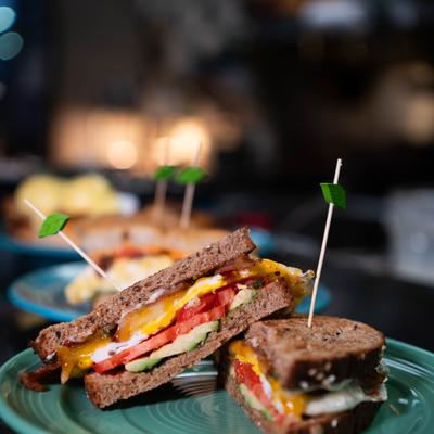 Breakfast sandwich, with fried egg, tomato, avocado, basil mayo, cheddar, and Monterey Jack.