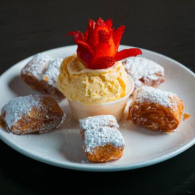 Beignets served with ice cream and strawberry garnish.