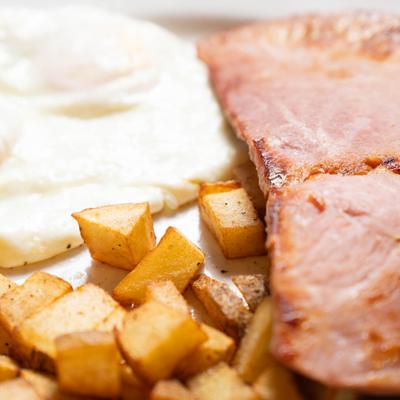 Fried eggs, grilled had, and breakfast potatoes.