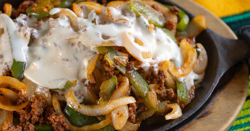 Fajitas with grilled onions, green peppers, chorizo, and cheese sauce