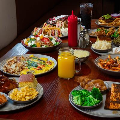 A wooden table filled with diverse dishes and drinks.
