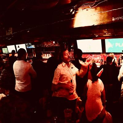 Dimly lit bar with people mingling and drinking