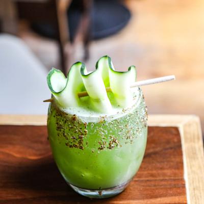 Pepino el Pyu cocktail garnished with a cucumber curl on a toothpick.