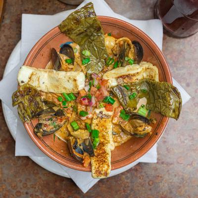 Mexican seafood stew served in a clay bowl.