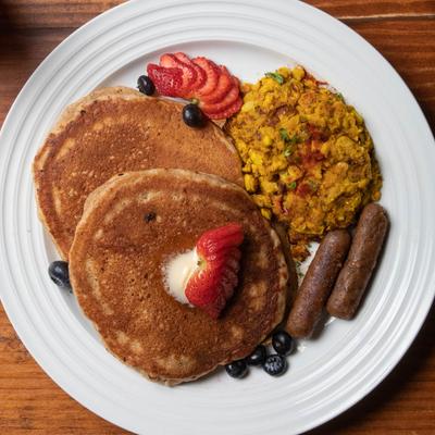 Platter with pancakes, chickpea scramble, seitan sausage, top view