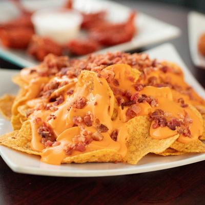 Nachos topped with melted cheese and bacon.
