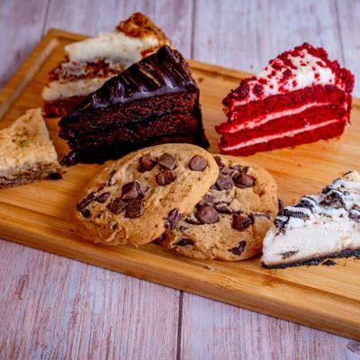 Dessert platter featuring various cake and pie slices, cookies and a cheesecake bar.