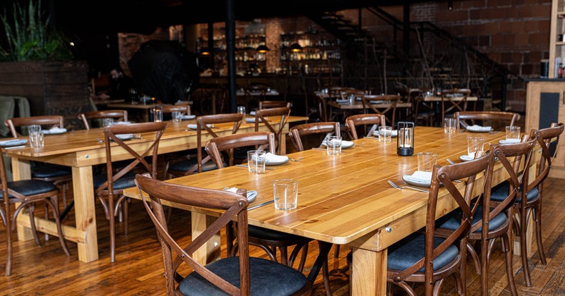 Interior, dining area, wooden tables with chairs, ready for guests, wooden flooring