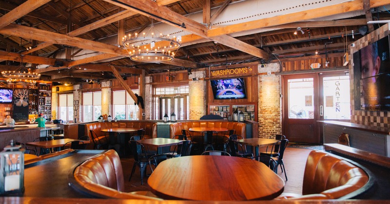 Interior, large U shaped leather padded seating booths with tables, chandeliers on the ceiling
