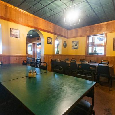 Interior featuring a wood-paneled wall, green tabletops, and a drop ceiling.
