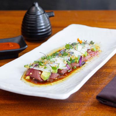 Bluefin tuna sashimi, with avocado, parmesan, microgreens, and truffle soy dressing.