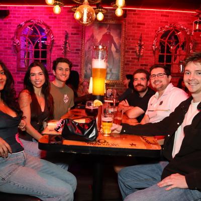 A group of people seated together at a restaurant table, smiling toward the camera.