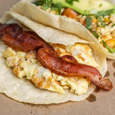 Breakfast tacos filled with eggs bacon and sausage.