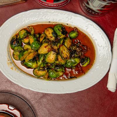 Brussels Sprouts served in reddish-brown glaze with diced chilies.