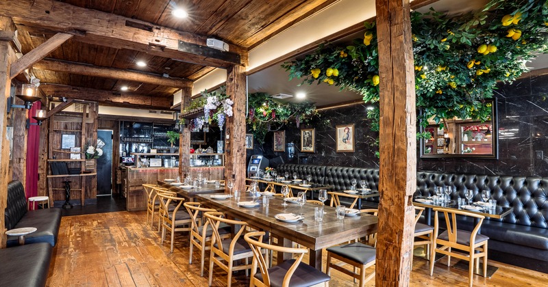 Rustic dining room with wooden beams, leather seating, and lemon greenery
