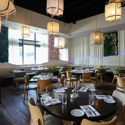 Interior, dining area, tableware on tables, floral decorations on the walls.