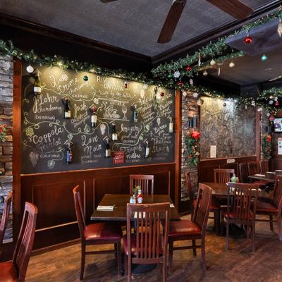 Restaurant interior with chalkboard wall, wooden furniture and festive decorations.