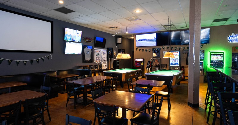 Interior featuring pool tables, multiple TVs, and wooden dining tables