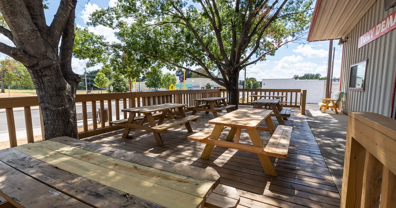 Cozy outdoor seating area with conjoining wooden tables and benches
