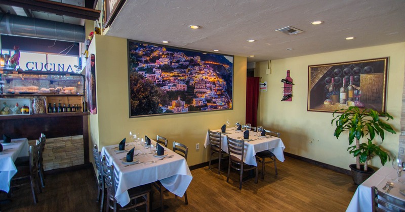 Inside, seating area with tables and chairs, painting on the wall