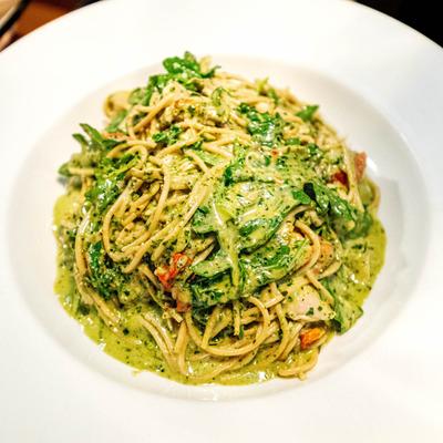 Spaghetti with a green pesto sauce.