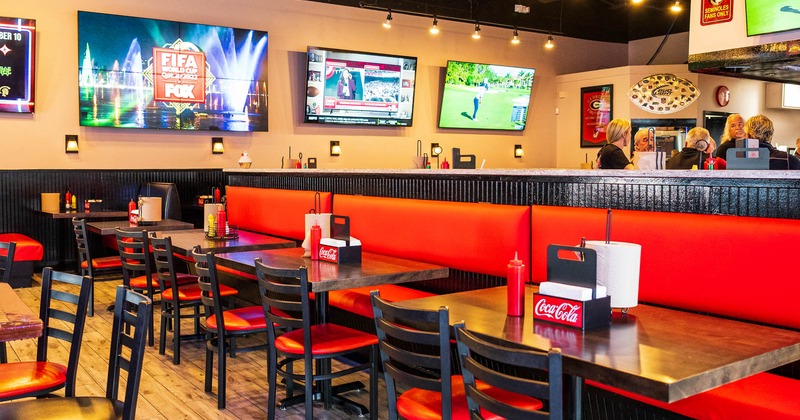 Inside, chairs, tables, TVs on the wall