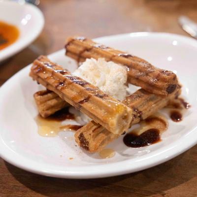Churros, with whipped cream and chocolate syrup.