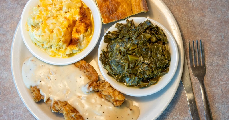 Fried chicken in gravy, with collard greens, mac & cheese and cornbread on the side