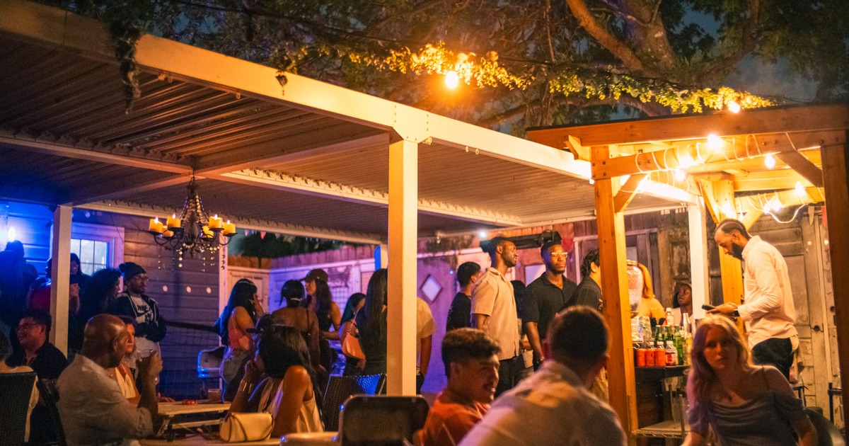Outdoor evening partywith people mingling, sitting at tables, and enjoying drinks