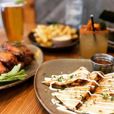 Quesadilla with other dishes and drinks on a table, close up.