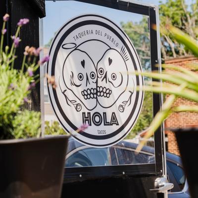 Restaurant signage featuring a distinct skull illustration  on a glass surface.