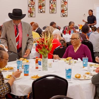 People having food and drinks at the table.
