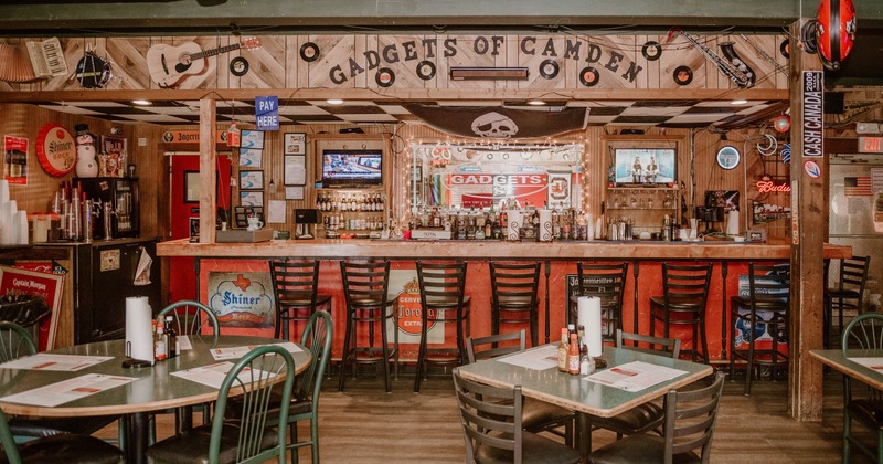 A bar with bar stools and tables