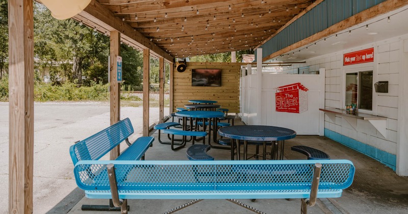 Outdoor seating area with blue benches, round tables