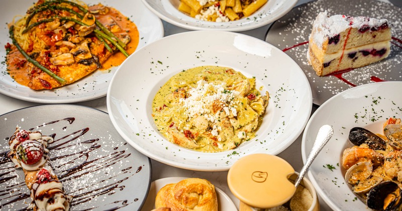 A table with different types of Italian dishes served on plates, top view