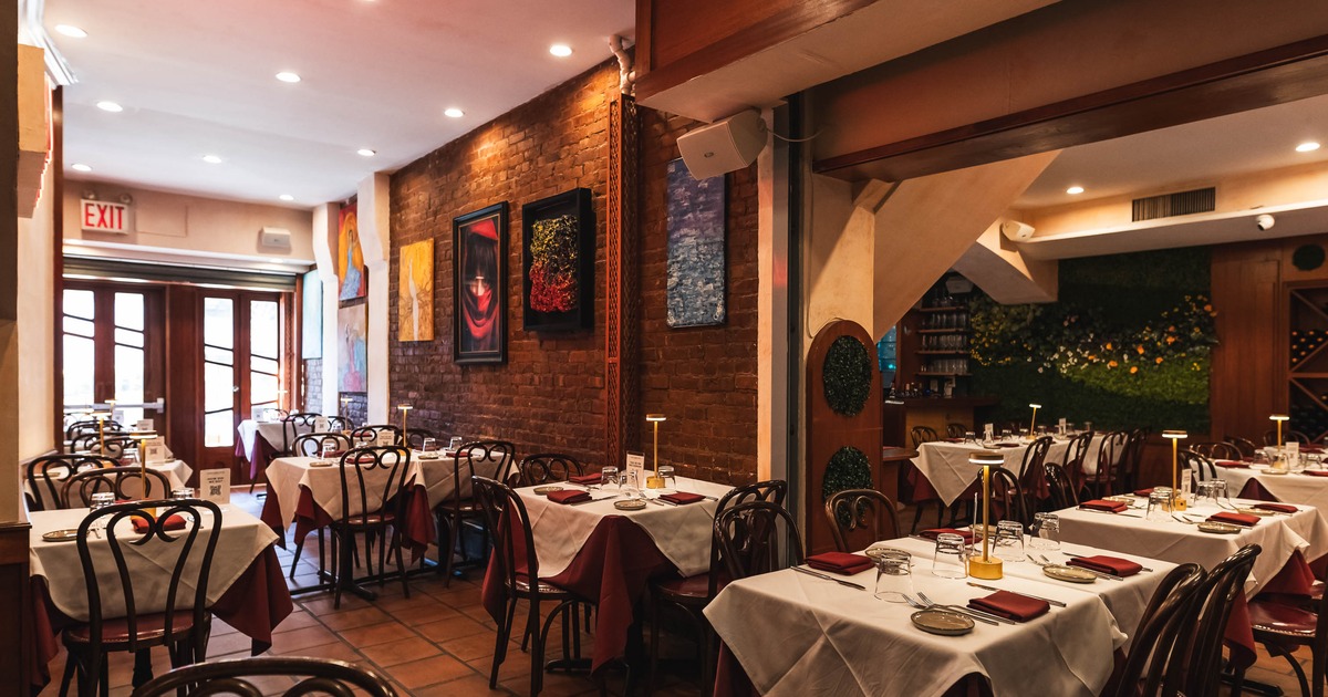 Cozy restaurant interior with warm lighting, brick walls adorned with colorful abstract art