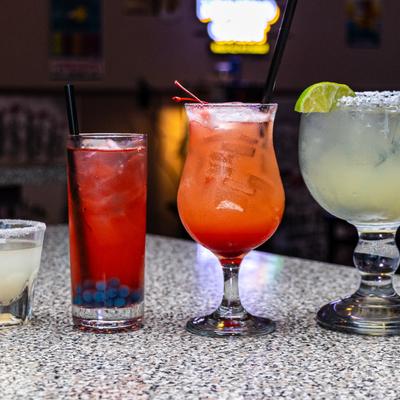 Colorful cocktails on a speckled counter.
