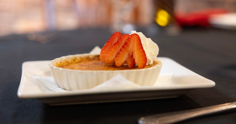 Creme Brulee topped with whipped cream and strawberry