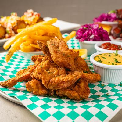 Crispy fried chicken served with fries, coleslaw, and dipping sauces.