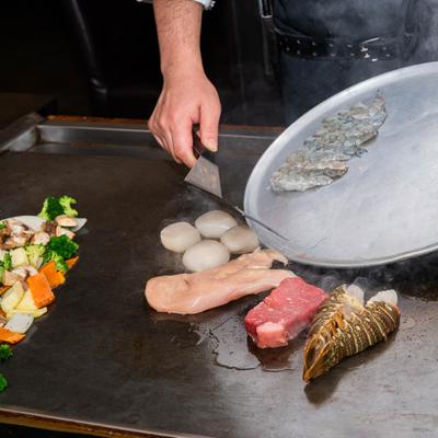 Chef grilling meat and vegetables.