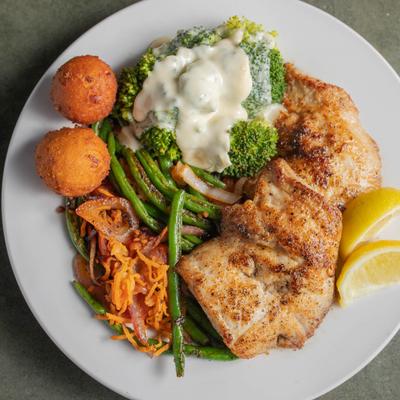 Grilled mahi served with blistered green bean medley, hushpuppies, and broccoli with cheese sauce