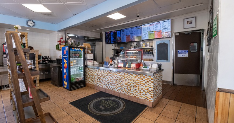 Old Market Grill restaurant counter with digital menu boards and beverage cooler