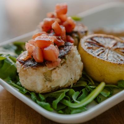Crab cakes topped with tomato and basil.