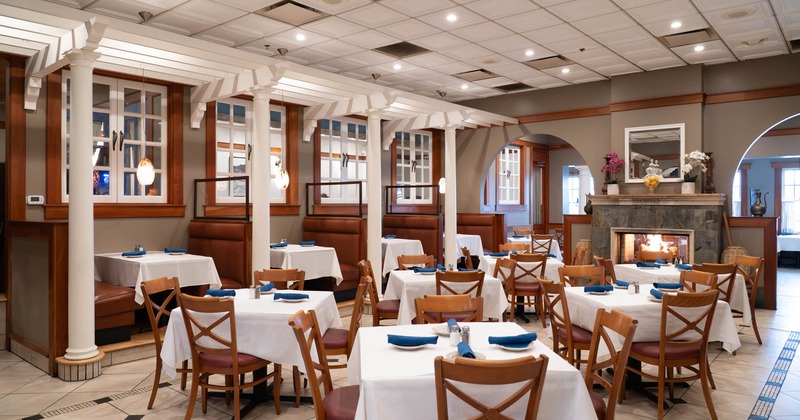 Interior, dining area, tables ready for guests, booths with tables, fire place