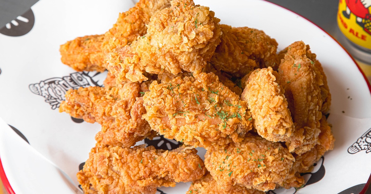 Crispy fried chicken garnished with herbs, close-up