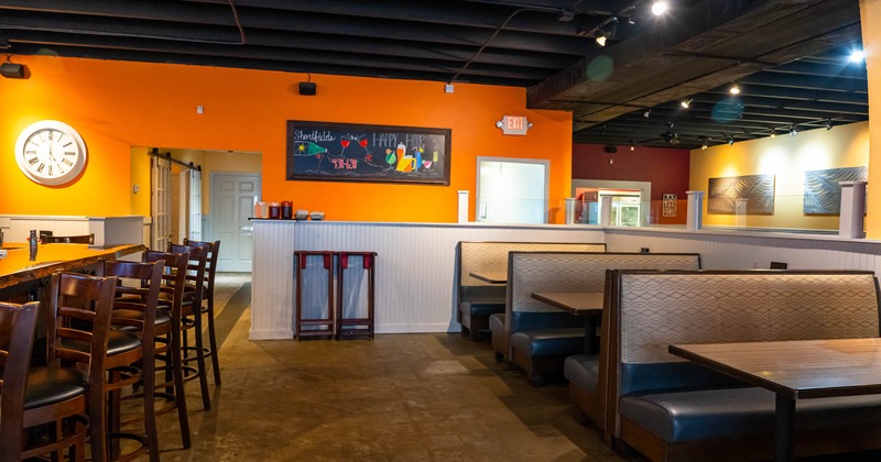 Restaurant interior with tables, chairs and paintings on the walls