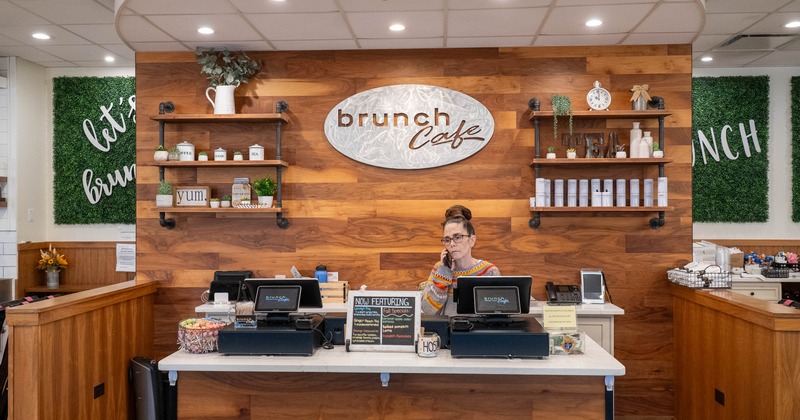 Interior, food counter, front view, sign wall behind the staff