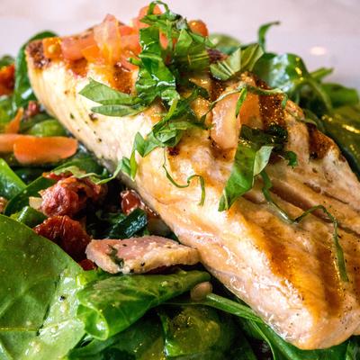 Pan seared salmon atop spinach salad