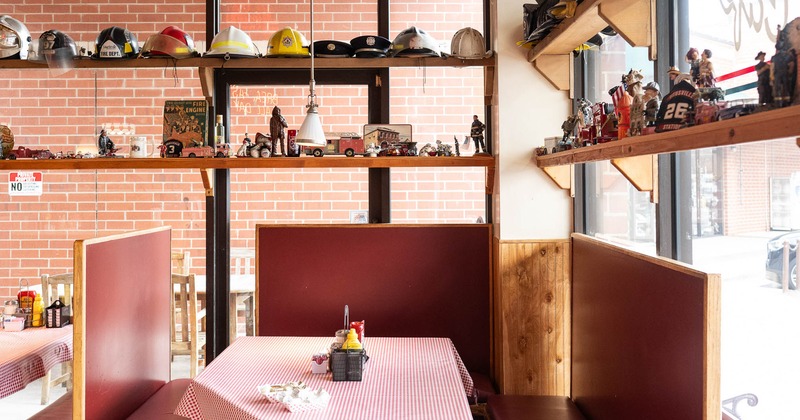 Interior of a diner with red booths, and helmets and collectibles on the shelves