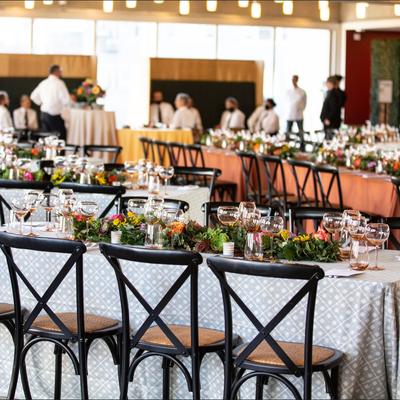 Banquet tables with floral arrangements and wine glasses set for guests.